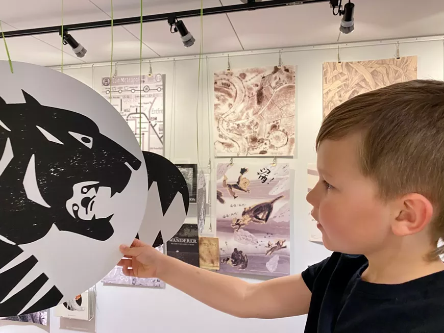 Oliver (age 6) inspects a hanging medallion that depicts a detail from an illustration in "Tierenduin" by Dutch author and illustrator, Geert Vervaeke, as part of the "Black White Grey" exhibit on loan from the International Youth Library in Munich, Germany and on display in the Worlds of Words Center.