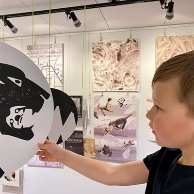 Image: Oliver (age 6) inspects a hanging medallion that depicts a detail from an illustration in "Tierenduin" by Dutch author and illustrator, Geert Vervaeke, as part of the "Black White Grey" exhibit on loan from the International Youth Library in Munich, Germany and on display in the Worlds of Words Center.